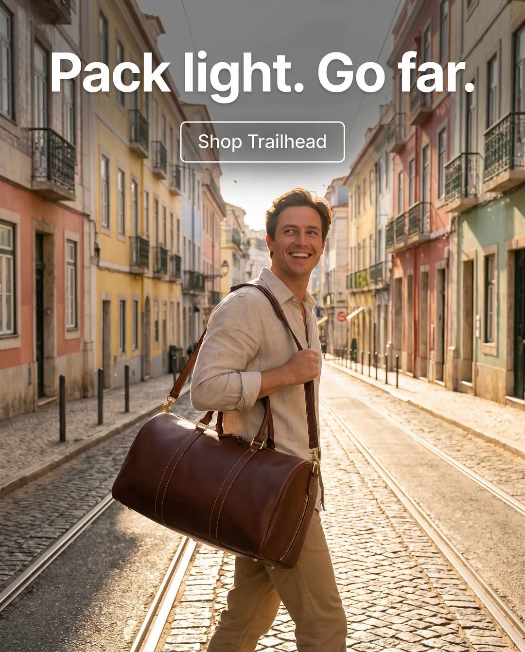 Pack light. Go far. — AI-made ad for Trailhead (fictional travel bag brand). Smiling traveller carrying a leather duffel bag down a sunny cobblestone street.